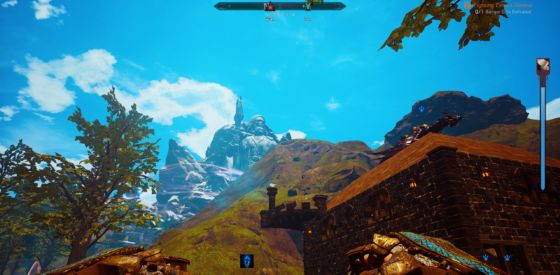 A distant sculpture carved from the mountains themselves with a player house in the foreground.